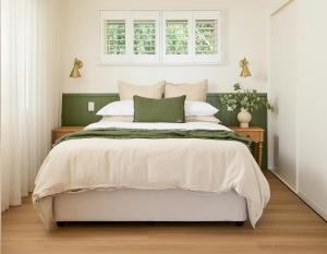 a bedroom with a large bed and a window at Oak Ridge Cottage in Maleny