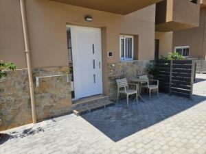 un patio con mesa y sillas junto a una puerta en Elounda Sunrise Apartments, en Elounda