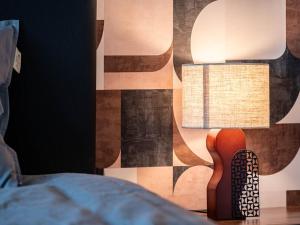 a bedroom with a lamp and a bed and a guitar at La laiterie de Claire in Bouillon