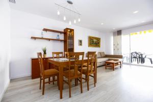 a dining room and living room with a table and chairs at Apartaments QUEENS 2A in Salou