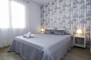 a bedroom with a large bed with two pillows at Apartaments QUEENS 2A in Salou +36 photos