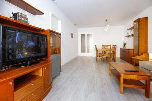 a living room with a flat screen tv on a entertainment center at Apartaments QUEENS 2A in Salou