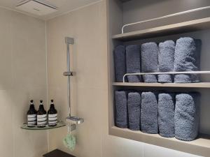 a bathroom with a bunch of towels on a shelf at SunU Seoul Stay - All Rooms 45m Panoramic Han River View - 4m Ceiling in Seoul +38 photos