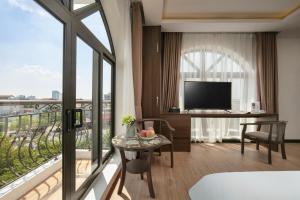 a room with a large window and a desk with a television at Royal Hotel & Spa Vinh Yen 2 in Háu Nữ