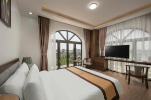 a hotel room with a large bed and a television at Royal Hotel & Spa Vinh Yen 2 in Háu Nữ +17 photos
