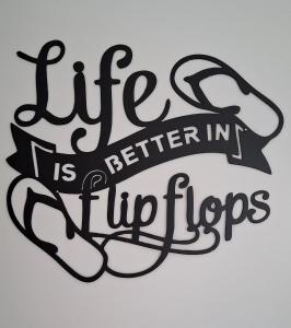 a sign that reads life is better in flip floppers at Flipflops in Culburra Beach