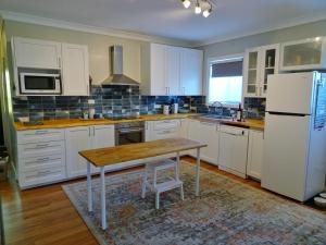 a kitchen with white cabinets and a wooden table at Flipflops in Culburra Beach