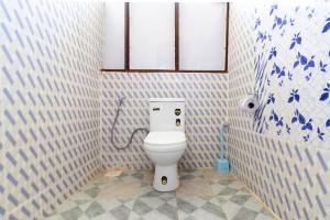 a bathroom with a white toilet in a room at Saba House 24 in Paje