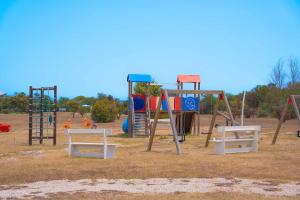 a park with a playground with a swing set at Cala Fiorita in Agrustos