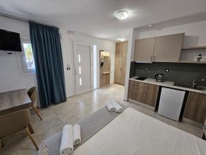 Una sala de estar con cocina y una mesa. en Elounda Sunrise Apartments, en Elounda