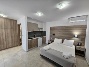 Un dormitorio grande con una cama y una cocina. en Elounda Sunrise Apartments, en Elounda