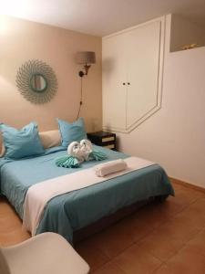 a bedroom with a bed with blue pillows and a mirror at Duplex vue Océan in Costa de Antigua