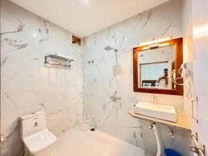 Un baño blanco con inodoro y lavabo. en Homestay Jaisalmer, en Jaisalmer