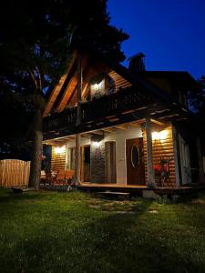 a house with a deck at night with lights at Leśna Ostoja 