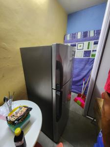 a stainless steel refrigerator in a room with a table at Lakaz in Port Louis