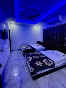two beds in a room with a blue ceiling at Lakshika Palace in Khātu