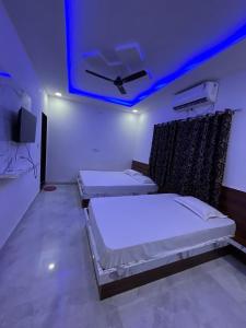 two beds in a room with a blue ceiling at Lakshika Palace in Khātu