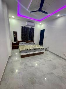 a bedroom with a bed and a purple light at Lakshika Palace in Khātu