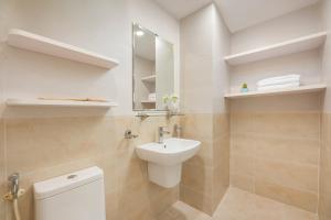 a bathroom with a sink and a toilet and a mirror at Fuji Hanoi Hotel and Apartment West Lake in Hanoi