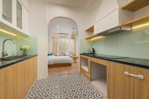 a kitchen with a sink and a room with a bed at Fuji Hanoi Hotel and Apartment West Lake in Hanoi