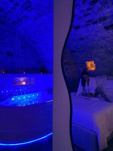 a woman sitting on a bed in a room with a tub at Sous les voûtes in Gargenville