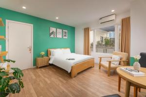 a bedroom with a white bed and a blue wall at Fuji Hanoi Hotel and Apartment West Lake in Hanoi