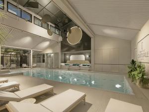 a large swimming pool with a bed in the background at Grand Hotel de Courtoisville in Saint Malo