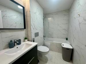 a white bathroom with a sink and a toilet at Lunara Studio #freeparking #pool in Tunari
