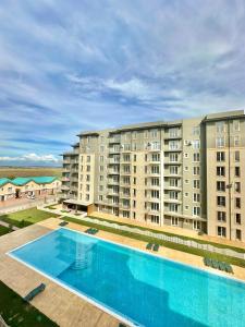 a swimming pool in front of a large apartment building at Lunara Studio #freeparking #pool in Tunari