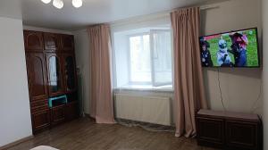 a living room with a tv and a window at Family and friends apartment in Ternopilʼ