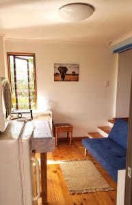 a living room with a blue couch and a refrigerator at Mount 'n Sea Retreat Studio in Victoria Bay