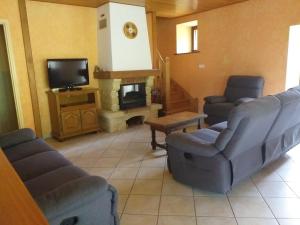 ein Wohnzimmer mit zwei Stühlen und einem Kamin in der Unterkunft Chez Maurice et Sylvie in Laveissière