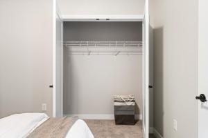 a bedroom with a white bed and a closet at Spacious 2BR CozySuites OTR Downtown #08 in Cincinnati