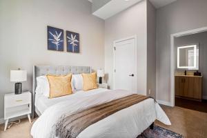 a bedroom with a large bed with orange pillows at Spacious 2BR CozySuites OTR Downtown #08 in Cincinnati