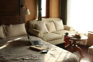 a living room with a couch and a bed at MiAmi Mountain Retreat in Bắc Yên