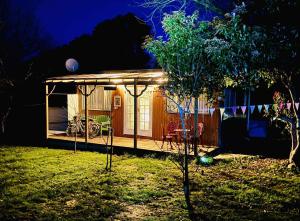 une maison avec un belvédère dans la cour la nuit dans l'établissement Wattle Creek Cottage with Breakfast Basket, à Amberley 5 autres photos