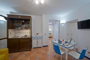 een keuken en eetkamer met een tafel en blauwe stoelen bij Le Anfore 2 - Amalfi Coast in Conca dei Marini