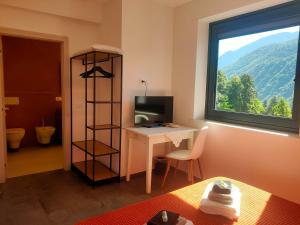 a room with a desk and a window at Casa Cuor di Castagno in Roncegno