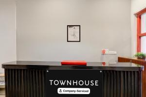 a counter with a town house sign on it at Townhouse Nagpur Junction Formerly Hotel Woodland in Nagpur
