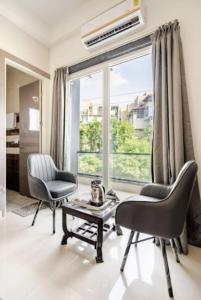 a living room with two chairs and a table and a window at The Royal Harmony in Greater Noida