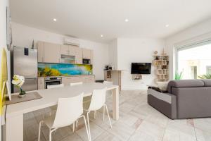 a kitchen and living room with a table and chairs at Unique luxury Villa Feriatum Lissa in Ždrelac