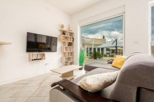a living room with a couch and a tv at Unique luxury Villa Feriatum Lissa in Ždrelac