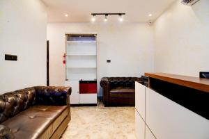 a living room with two leather chairs and a couch at Townhouse Oak Moulali Bus Terminal Formerly Creek Row in Kolkata