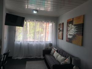 a living room with a couch and a window at Costa Verde Retreat 2 - Upper Floor in Quepos
