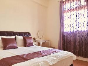 a bedroom with a large bed and a window at 白宮七哩香園民宿 in Hou-p'an-ts'un