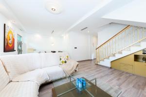 Una sala de estar con un sofá blanco y una escalera. en Maravillas, en La Mata