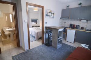 a kitchen with a table and a room with a bed at Naya Lux Apt in Kastoria