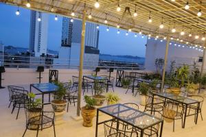 a group of tables and chairs on a balcony with lights at Retro Homestay Hạ Long in Ha Long