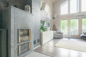 un soggiorno con camino e divano di Hideout Villa Swan a Säräisniemi Altre 9 foto