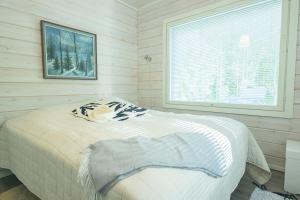 una camera da letto con un letto in una stanza con una finestra di Hideout Villa Swan a Säräisniemi